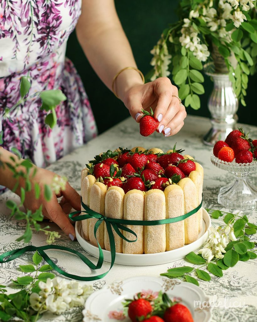 Tort tiramisu cu fistic si capsuni servit pe masa festiva, desert elegant fara coacere pentru aniversari sau mese in familie