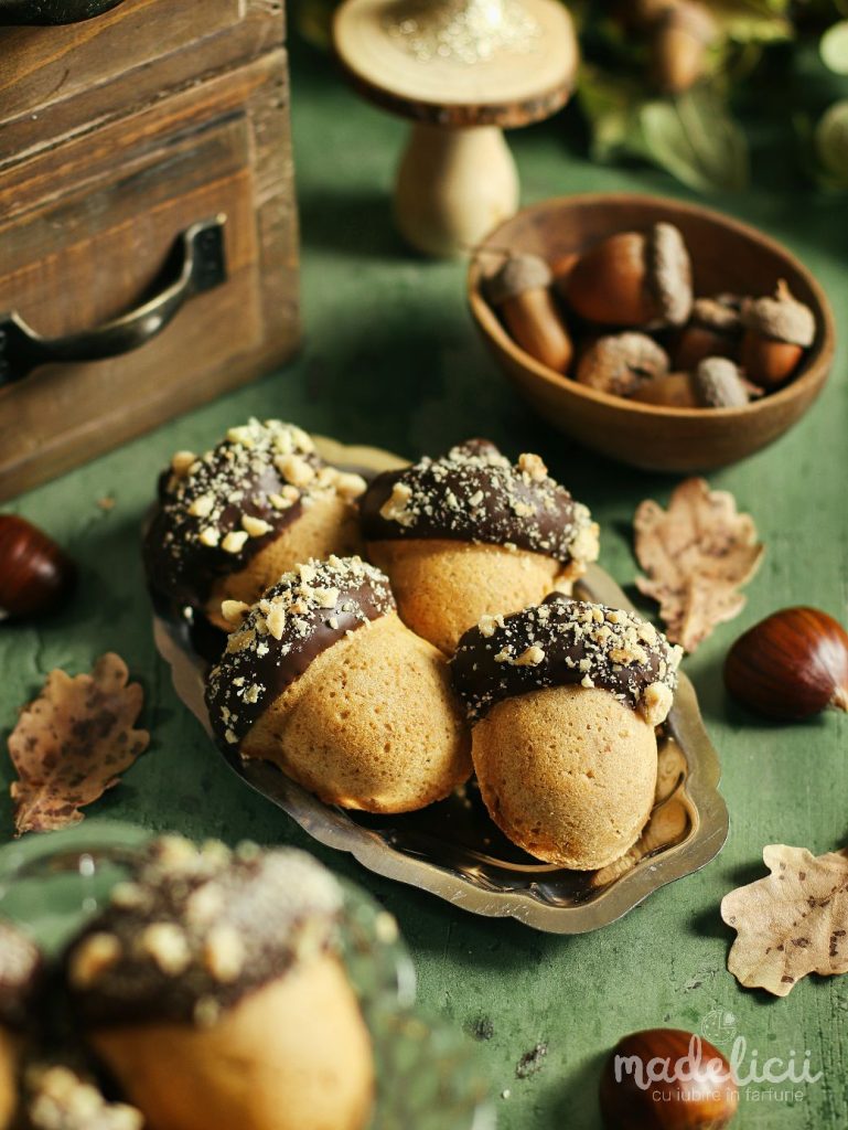 Briose in forma de ghinda decorate cu ciocolata si alune, fotografiate pe fundal de toamna