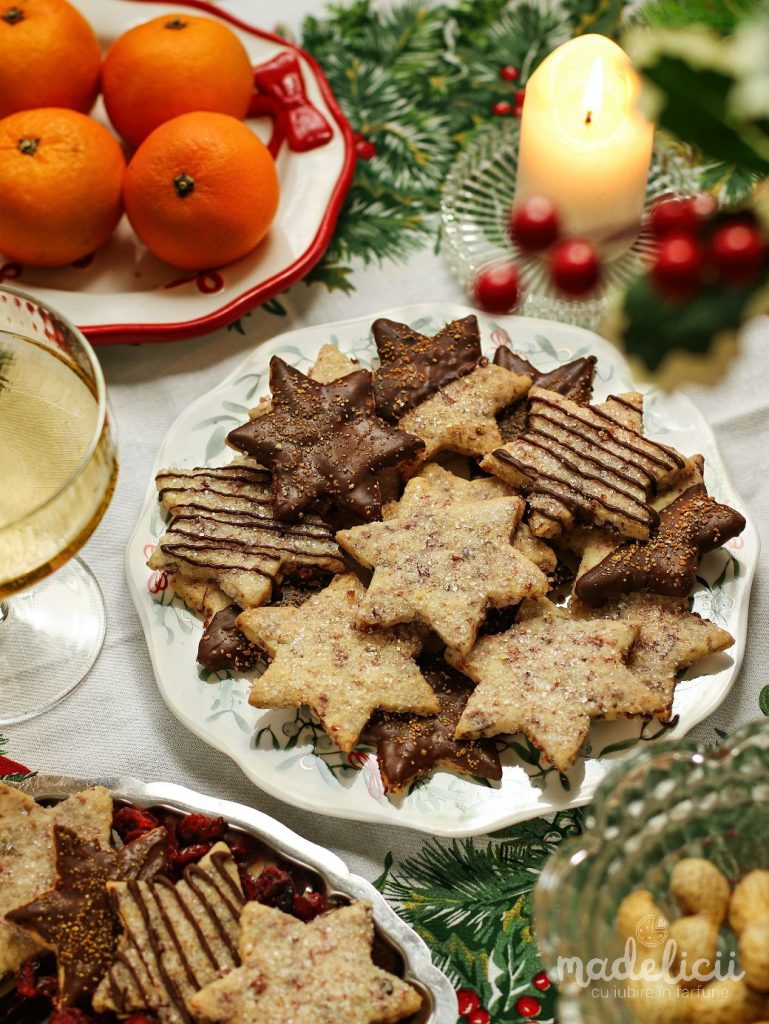 Fursecuri cu merisoare, coaja de portocala si ciocolata pe platou festiv, alaturi de decoratiuni de Craciun si lumini calde